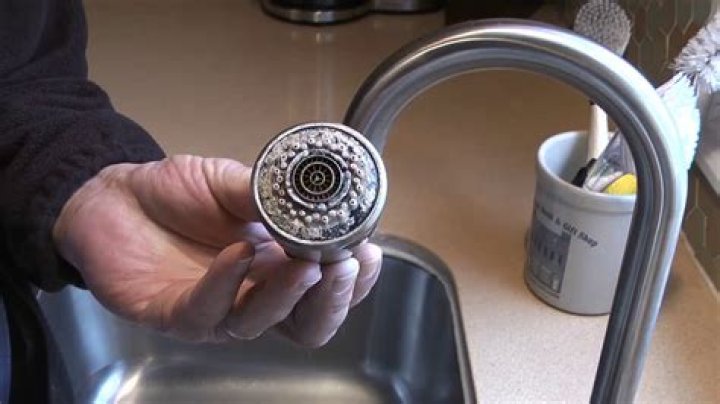 How do you clean a kitchen faucet sprayer head?